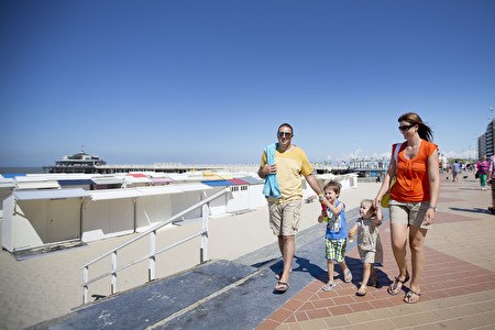 une famille d'été avec des enfants se promène le long de la digue