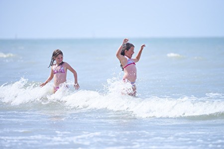 Deux filles jouent dans les vagues de la mer.